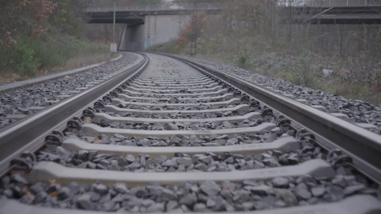 Empty Railroad Tracks Leading Under a Bridge
