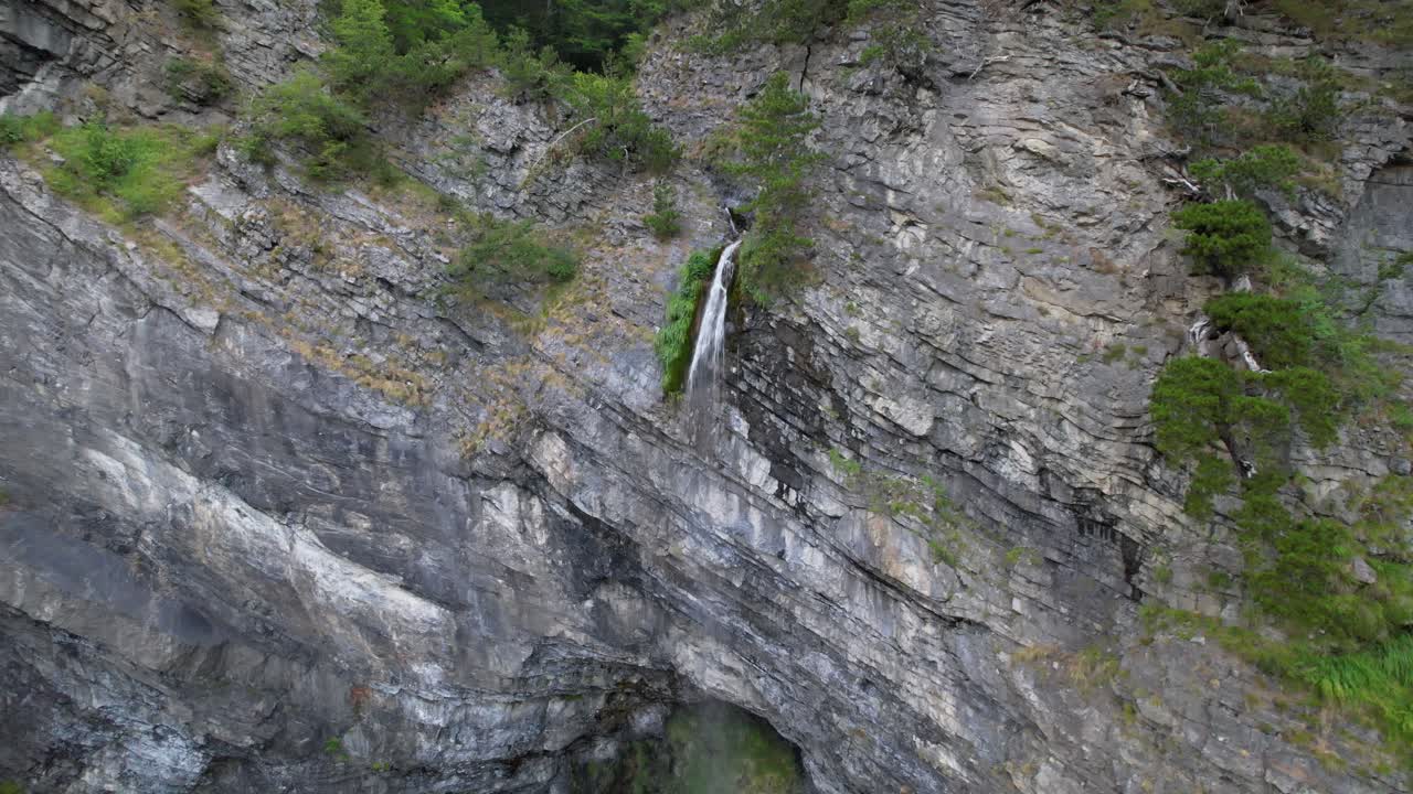 Cascata sulle montagne delle Alpi in Albania con portata d'acqua ridotta nella calda stagione estiva.