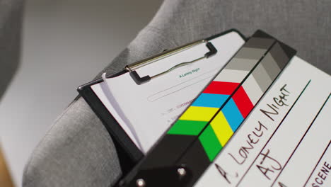 close up of film clapperboard or slate with production details and script shooting movie or video in studio