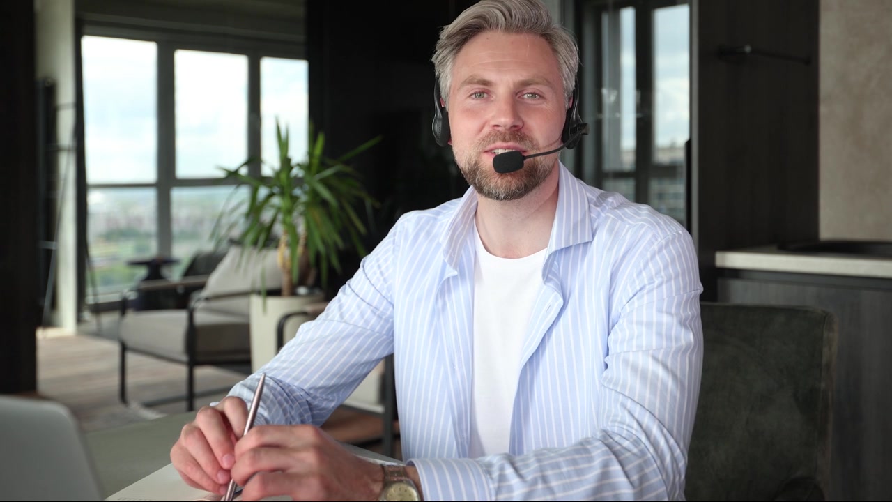 Professionel mand med headset taler under videoopkald