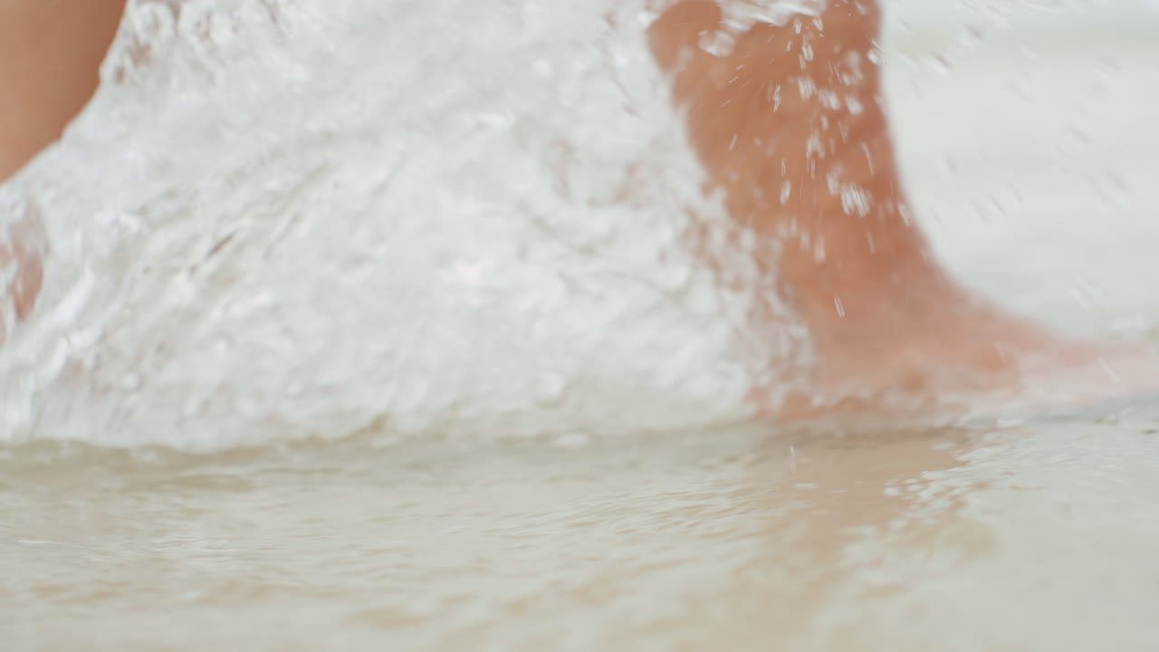Dolce donna caucasica che cammina lungo la costa dell'isola, acqua bassa e morbida intorno alle caviglie, passi silenziosi e riflessivi che creano leggere increspature, ricercatrice consapevole che si gode un momento tranquillo in riva al mare e la calma interiore.