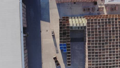 con un suave ascenso, el avión no tripulado revela la propiedad de la fábrica, revelando gradualmente pilas de cajas dentro