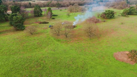 people burning stubble in a green field. aerial view