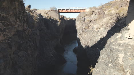 Drone flying beneath the bridge at &quot;La Pasarela,&quot; a magnificent spot near Bardas Blancas, Mendoza, Argentina, capturing the breathtaking scenery