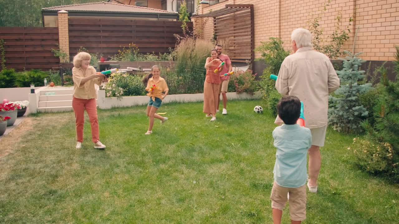 Cheerful Big Family Playing With Water Guns