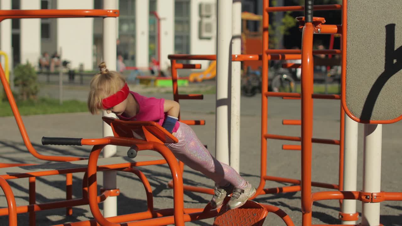 chica joven en ropa deportiva haciendo ejercicios de flexión en el patio de recreo. entrenamiento para niños. niño atlético