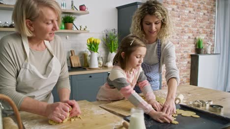 Video-Eines-Mädchens-Mit-Mutter-Und-Oma,-Das-Osterplätzchen-Backt