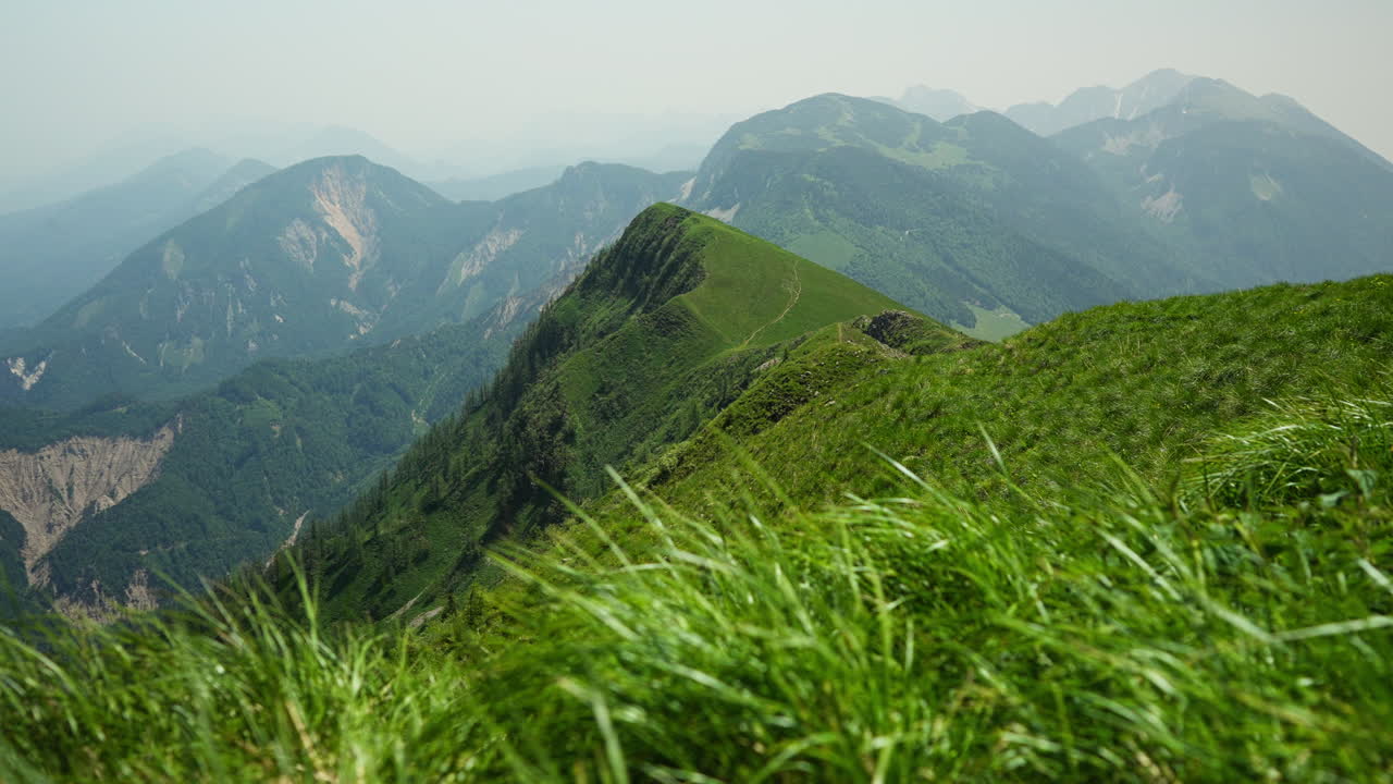 Scenic view of a mountain ridge in the Karavankas, Slovenia, with breathtaking sights of the surrounding Slovenian Alps. Peaceful summer day in the highlands, perfect for hiking and nature lovers.