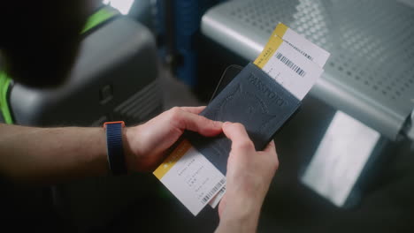 person holding passport and boarding pass at airport