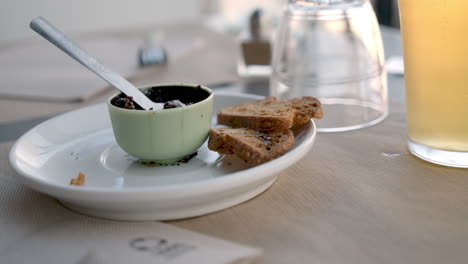 sencillo plato de desayuno rústico con un plato oscuro, pan tostado y una bebida