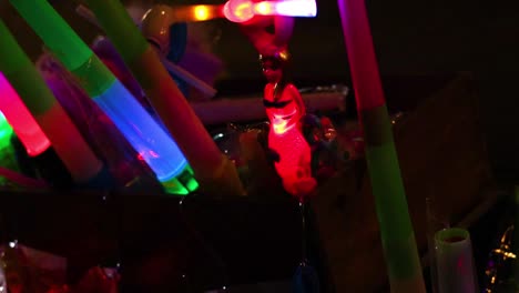 a close-up view of colorful neon sticks and glowing toys illuminating the darkness.
