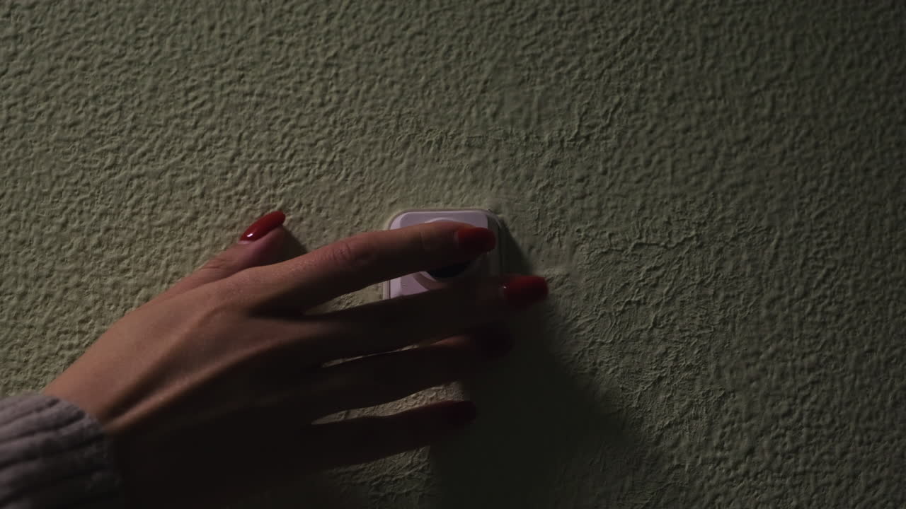 mujer encendiendo un interruptor de luz