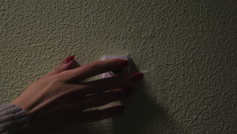 woman turning on a light switch