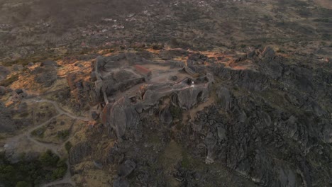 Aerial-circling-over-Monsanto-castle-ruins-during-sunrise,-Portugal