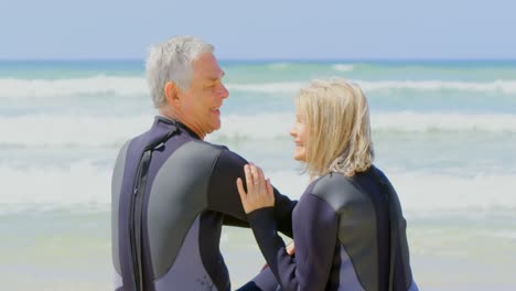 vista trasera de una pareja caucásica senior activa interactuando entre sí en la playa 4k