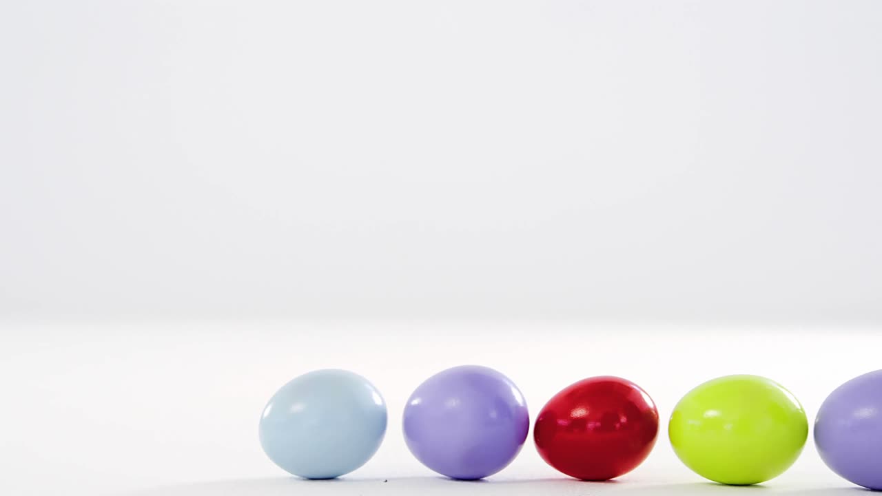 huevos de pascua en una fila con un conejo de pascua de juguete