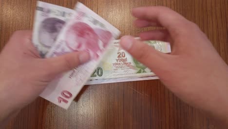 a teenager sorting each turkish lira banknote by value, with portrait of ataturk, founder of republic of türkiye on top