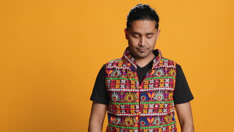 Happy-man-in-traditional-attire-smiling,-studio-background