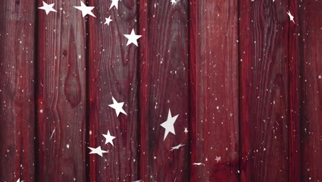 animation of christmas stars falling over burgundy wooden background