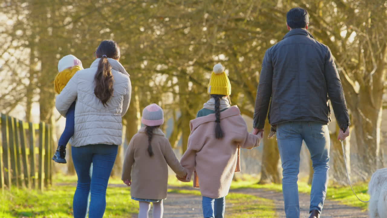 다운 증후군을 고 있는 가족: 딸과 애완견이 함께 가을이나 겨울에 시골에 산책하는 가족.