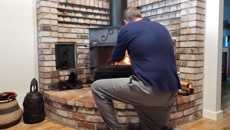 male warm-up cold hands beside fireplace in home lounge