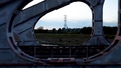 flying through construction of steel railway bridge, dusk time