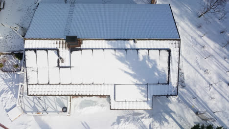 birds eye drone shot over snowy solar cells, melting on a sunlit house roof