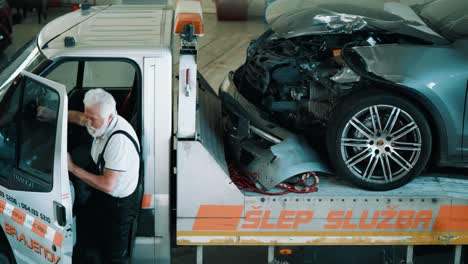 tow truck towing a broken vehicle in garage