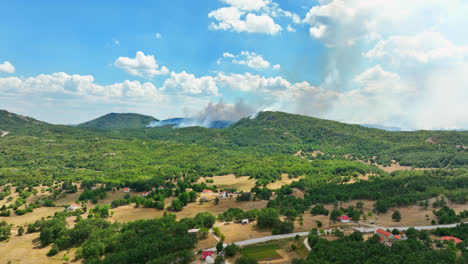 Aerial-ascending-shot-of-a-smoking-wildfire-in-the-highlands-of-the-southern-Europe