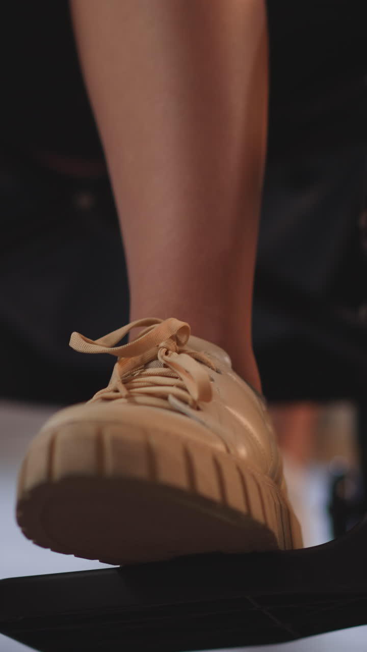 Legs of person with disability with cerebral palsy sitting in wheelchair on blurred background. Nurse pushes medical equipment with patient closeup