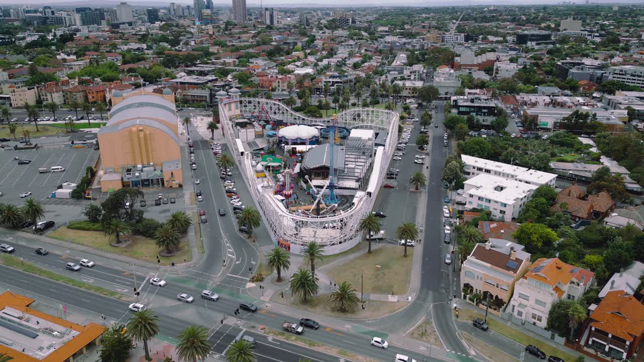 Drone footage of Luna Park, an amusement park at St Kilda Beach and the traffic moving along the beach front.