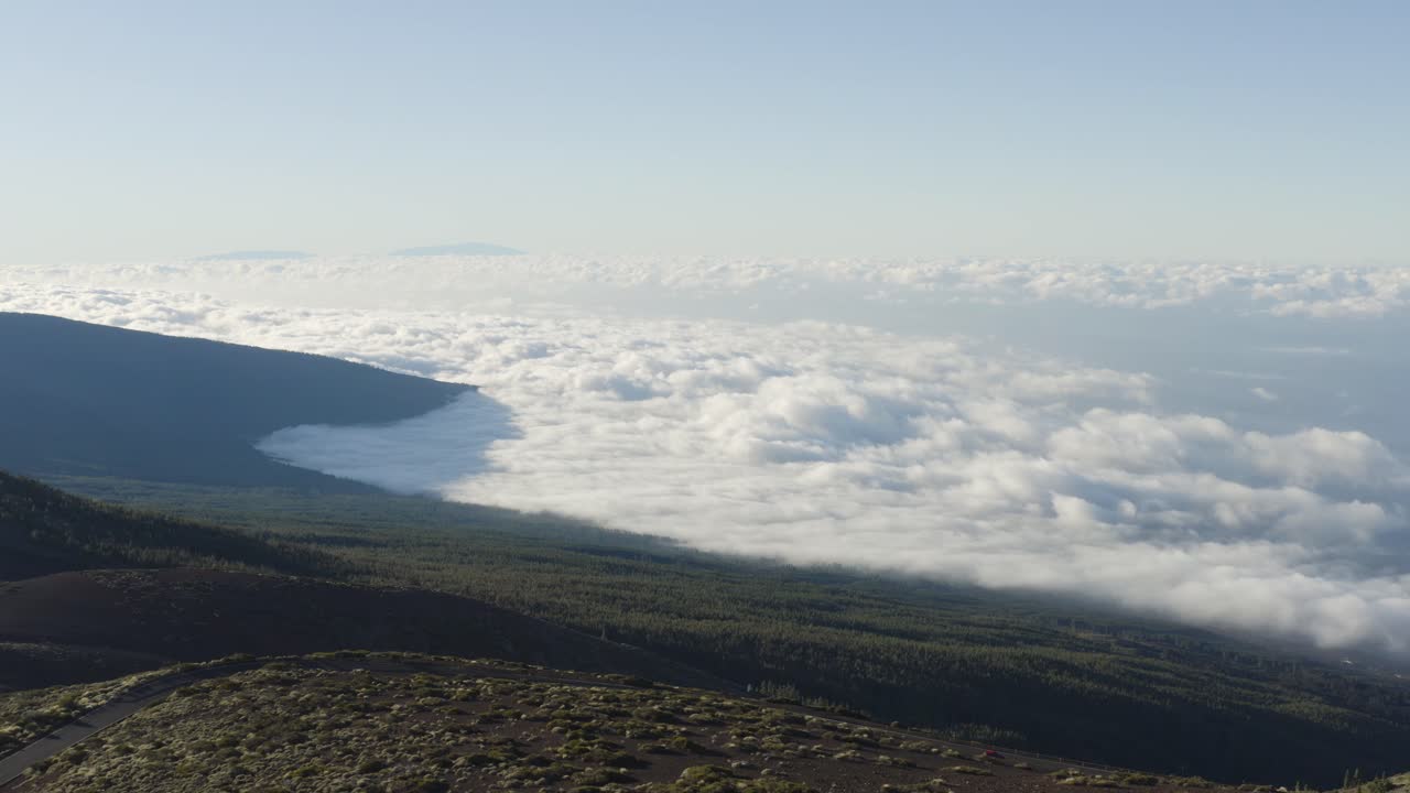 Rolling fluffy cloud bank on Teide, Tenerife mountain and national park. Aerial high angle.