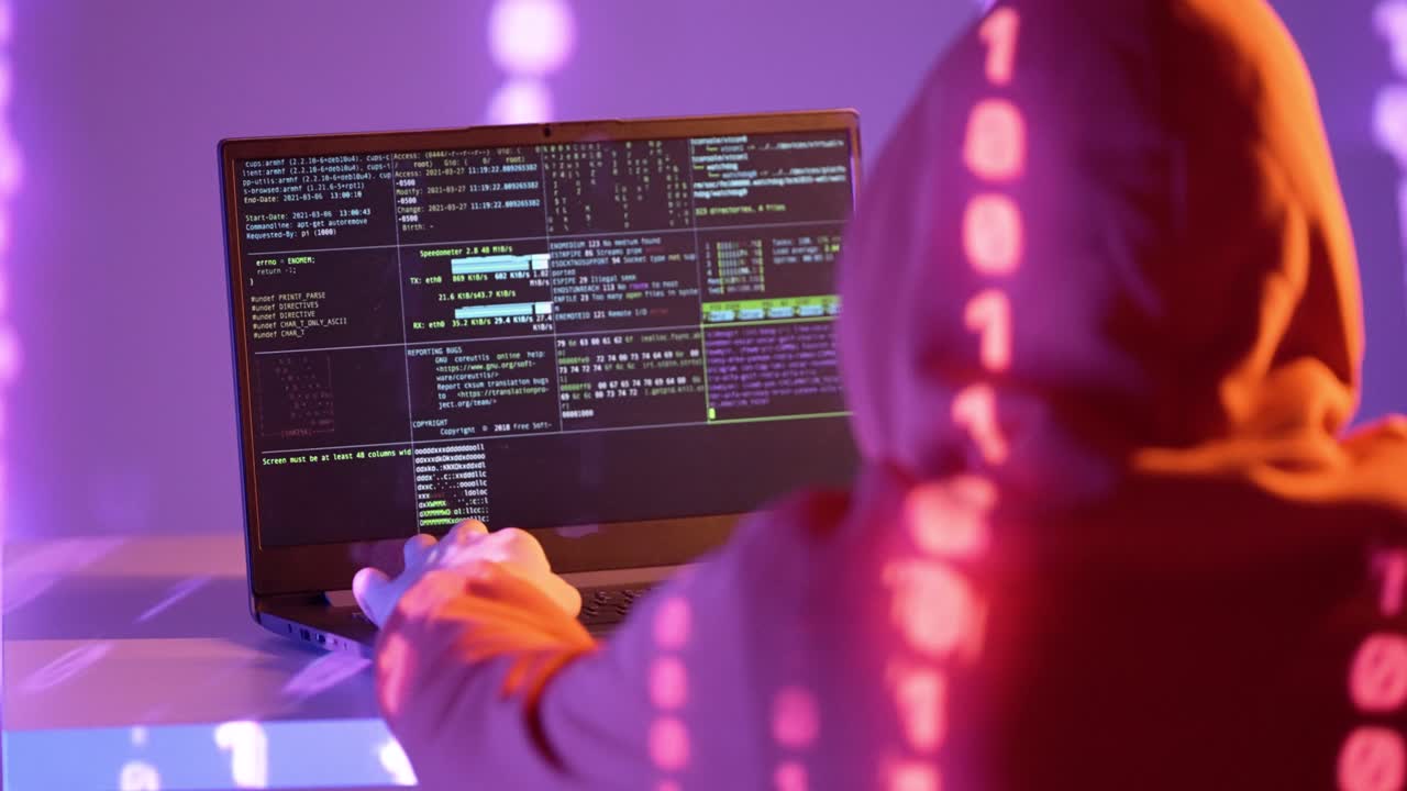 A hooded figure faces a laptop displaying terminal code, surrounded by glowing binary light in a violet-lit space, symbolizing system breach and deep-layer digital operations