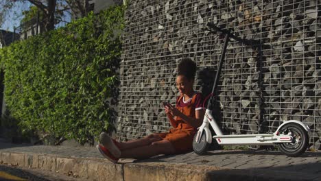 mixed race woman sitting on sidewalk