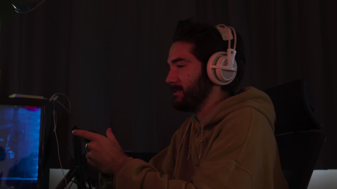 Male gaming with a game pad trying hard and celebrating erratically