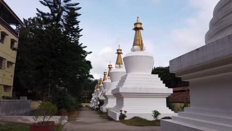 grandes estupas que albergan restos terrestres de buda y sus seguidores en el templo de oro del asentamiento tibetano en bylakuppe, india.