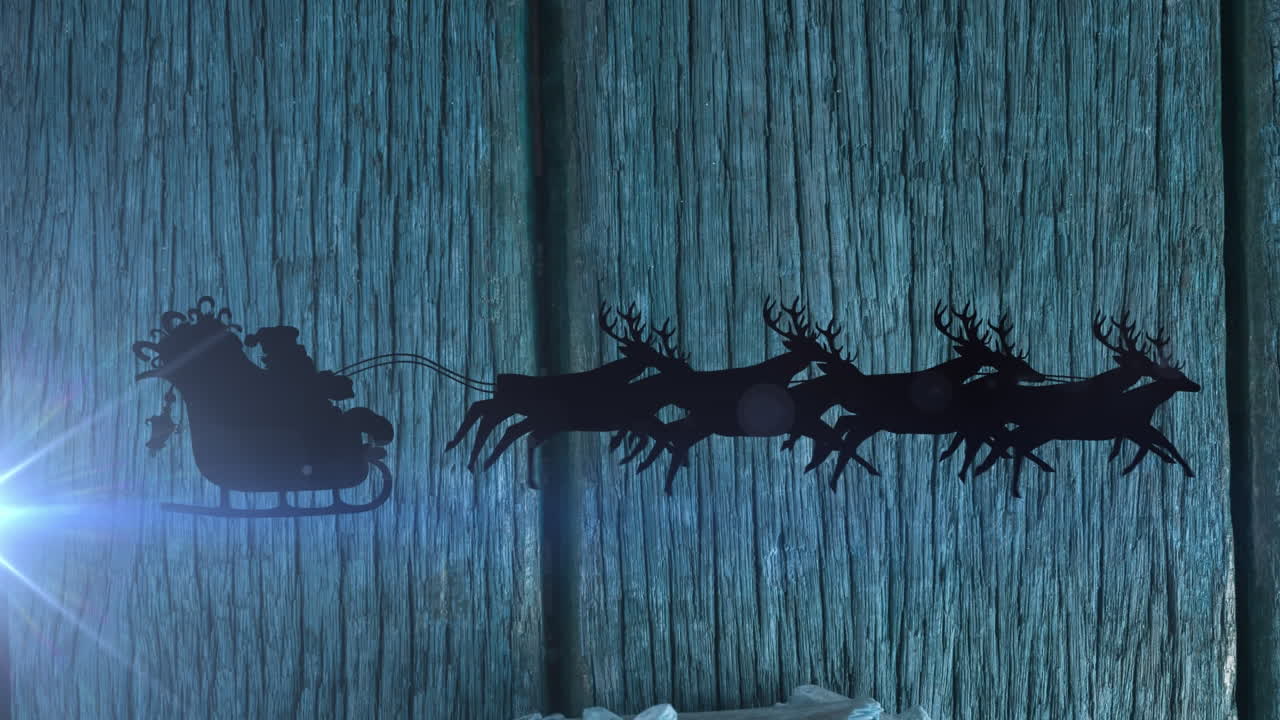 Animation of light trails and santa claus in sleigh with reindeer over wooden background