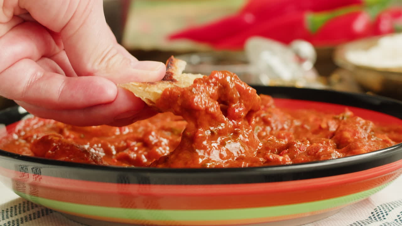 Assorted indian sri-lanka food set on wooden background. Dishes and appetisers of indeed cuisine, rice, lentils, paneer, samosa, spices, masala. Bowls and plates with indian food top view chicken. High quality 4k footage