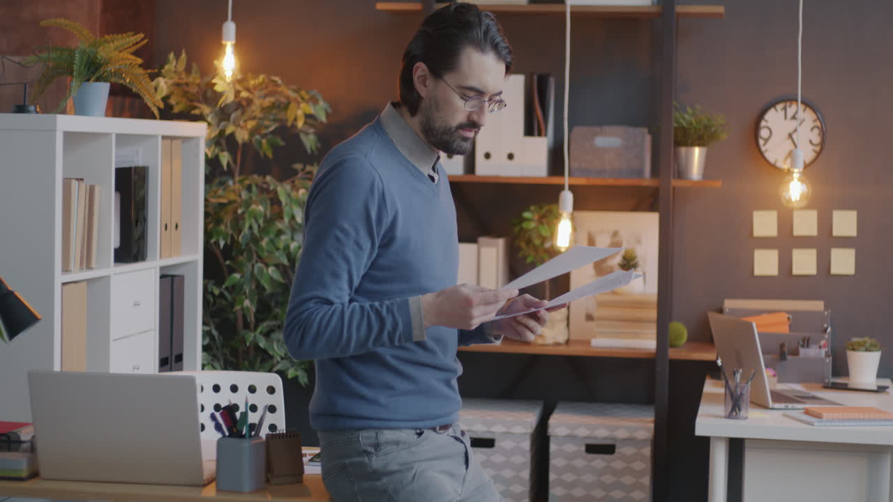 Man in an office holding documents