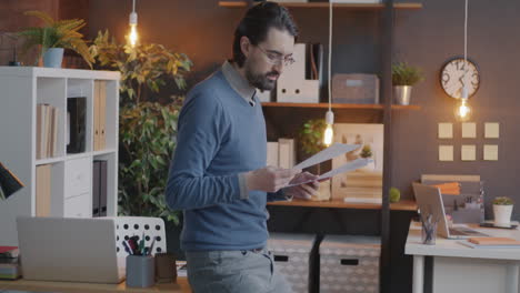 man in an office holding documents