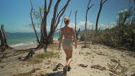 following a woman exploring coastal landscape of costa rica at cahuita point