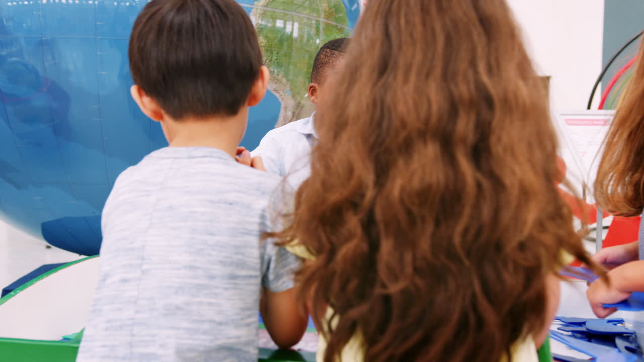 과학 센터 에서 퍼즐 을 하는 어린 반 친구 들 의 그룹