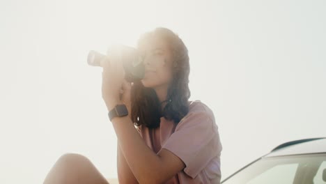 woman taking photo with vintage camera outdoors