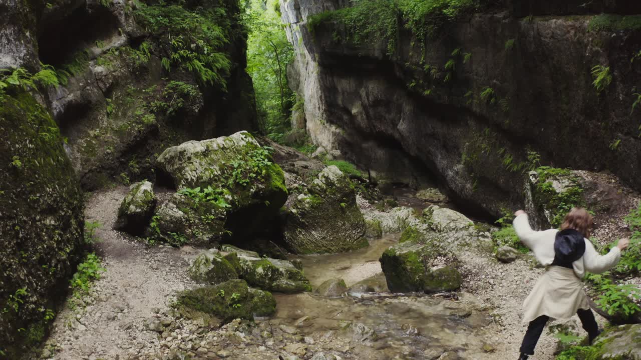 mujer caminando a través de un cañón de musgo