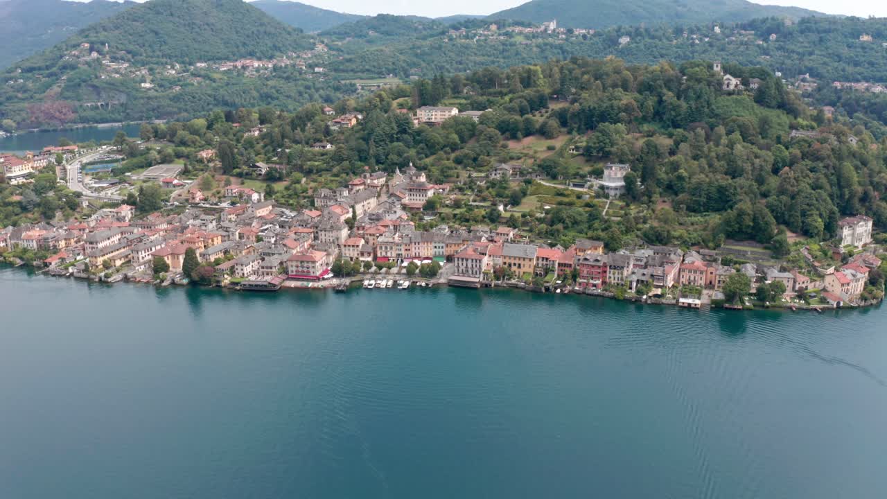 İtalya'daki sakin Orta Gölü'nde yer alan San Giulio Adası, arka planda yemyeşil tepelerle tarihi mimariyi sergiliyor, havadan görünüm