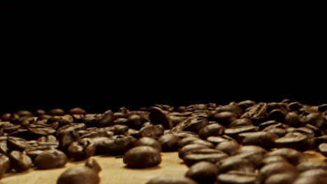 a bunch of coffee beans thrown on a wooden surface