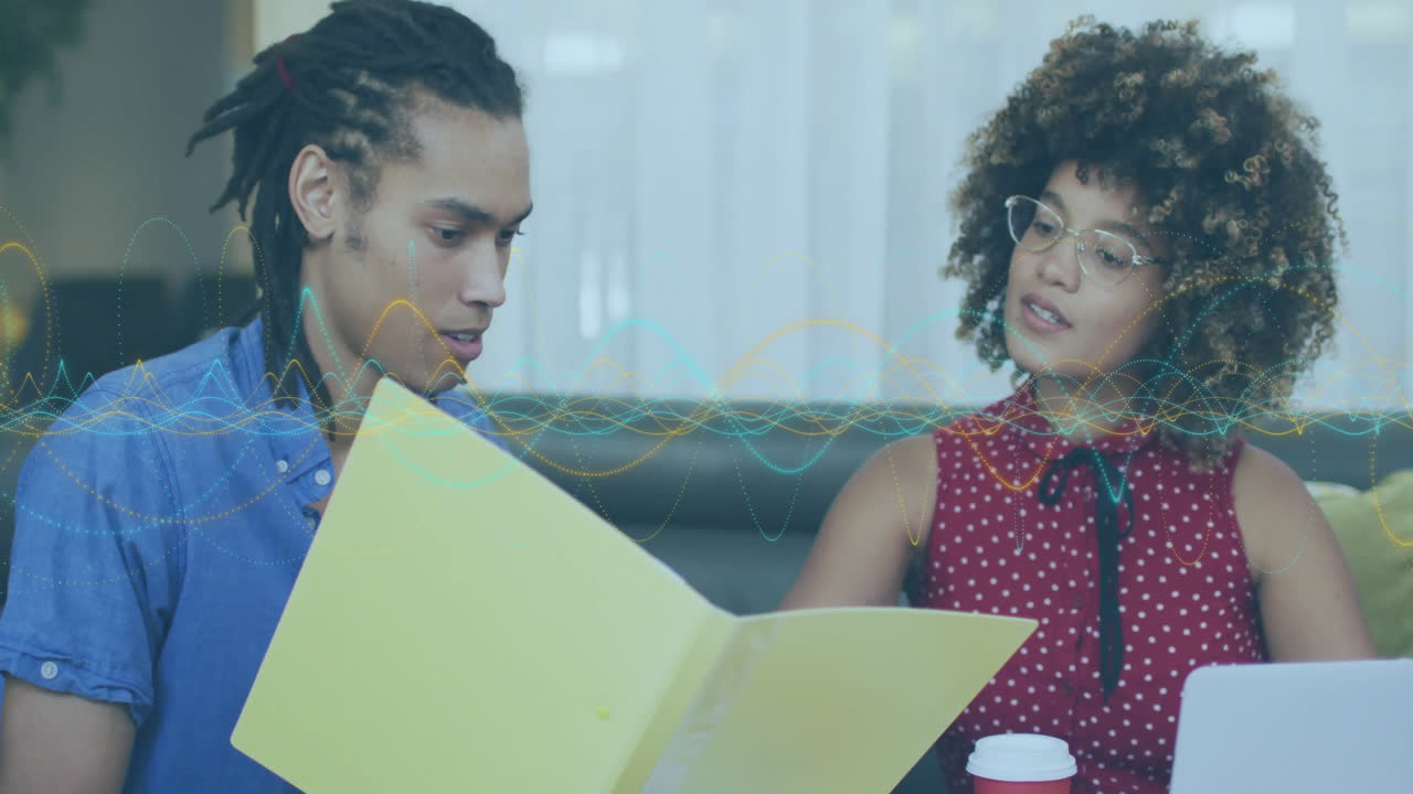 Male and female marketers reviewing folder and laptop, displaying animated business growth chart