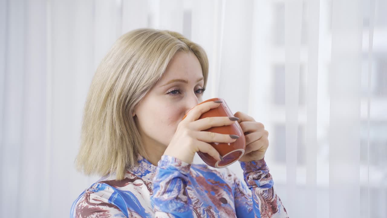 긍정적인 행복한 여성 평화롭고 창문  ⁇ 에서 휴식을 취합니다.