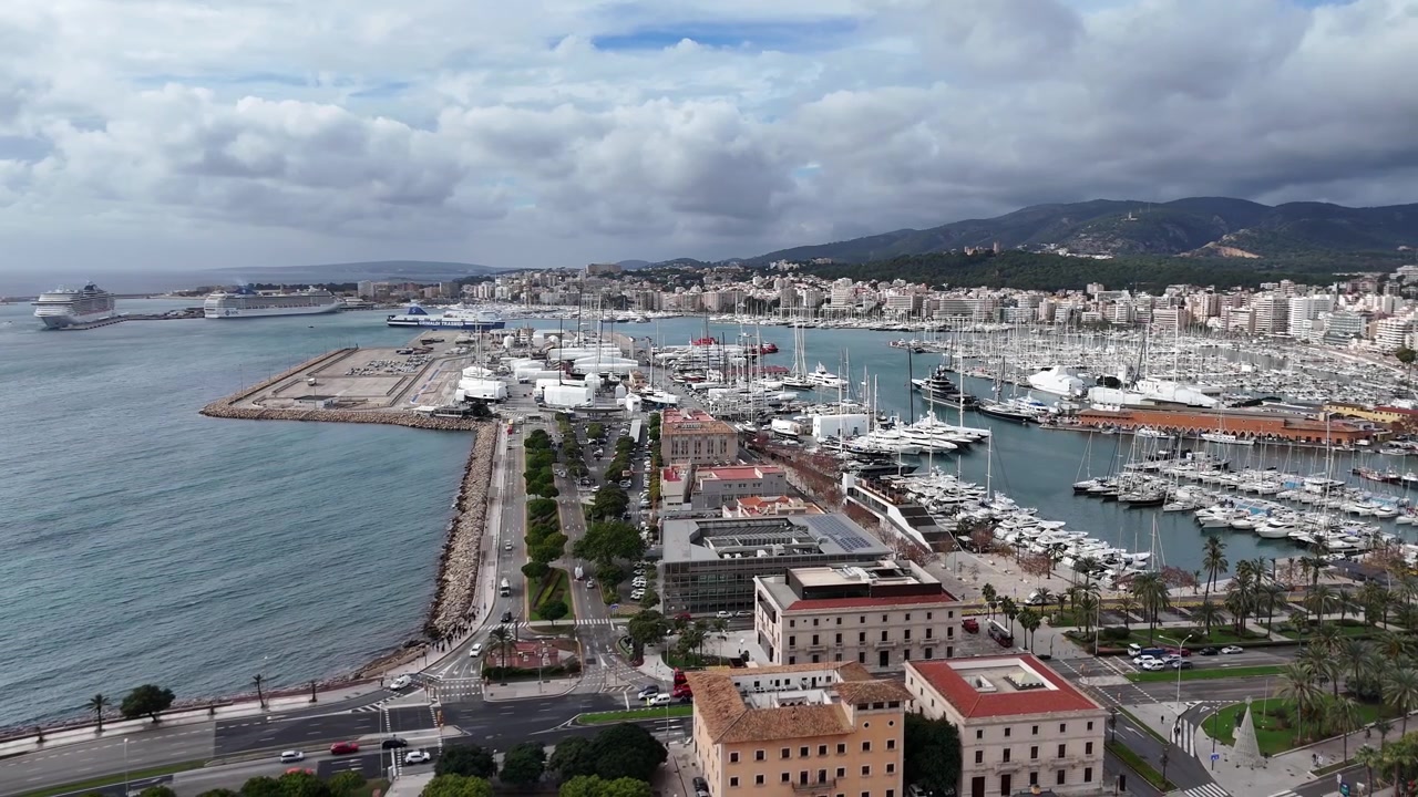 Bulutlu gökyüzü altında tekneler ve şehir manzarasıyla Palma de Mallorca marinası, hava çekimi