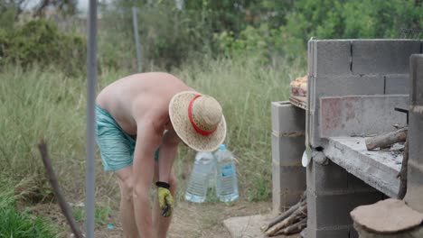 man pouring olive oil into pan for outdoor cooking